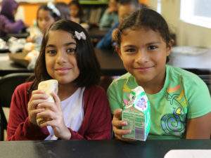 Two young girls smiling at the Summer Lunch Program
