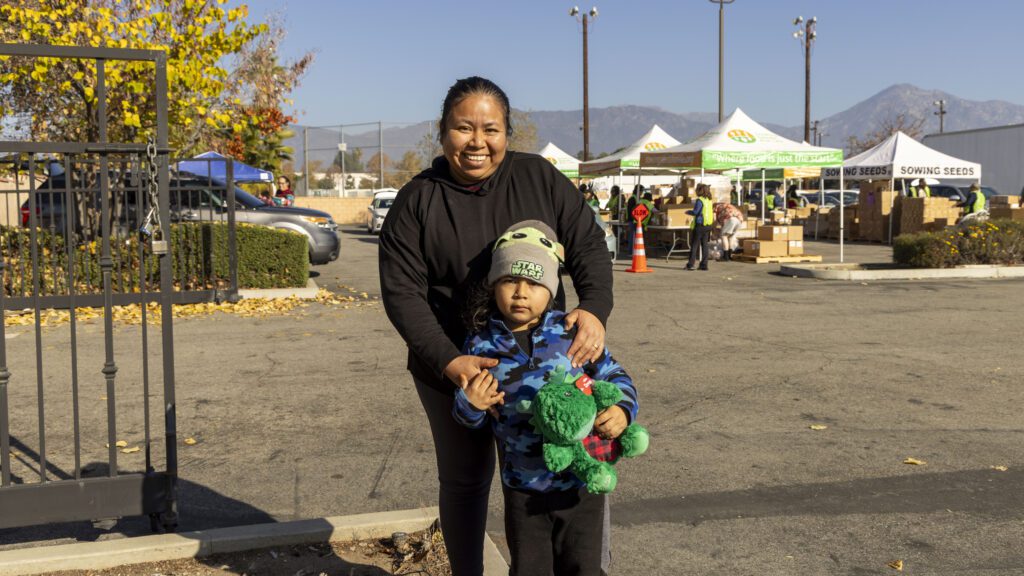 Maria and her young son pick up food at Sowing Seeds for Life in Pomona.